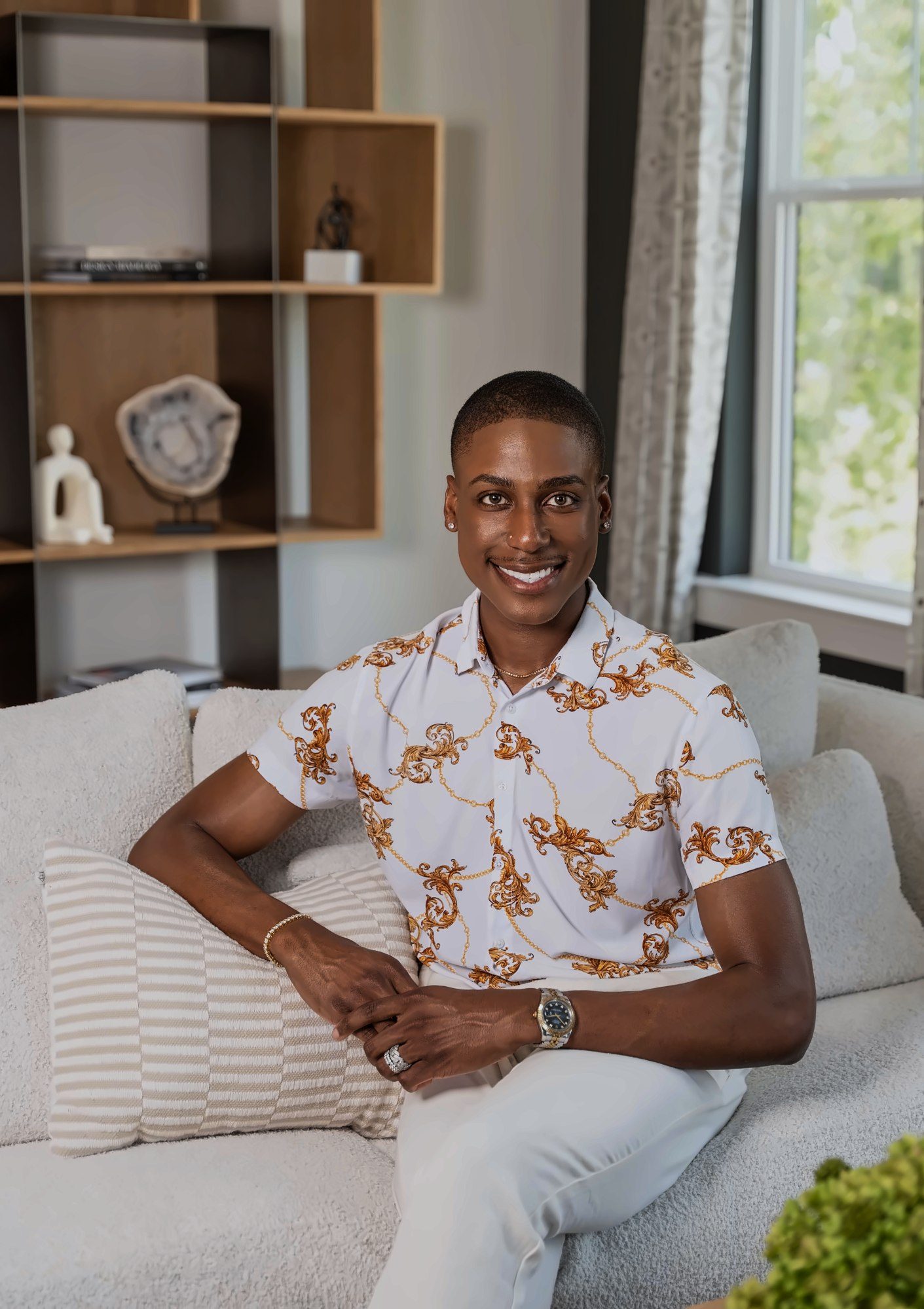 Agent smiling on a cream sofa in a styled living room