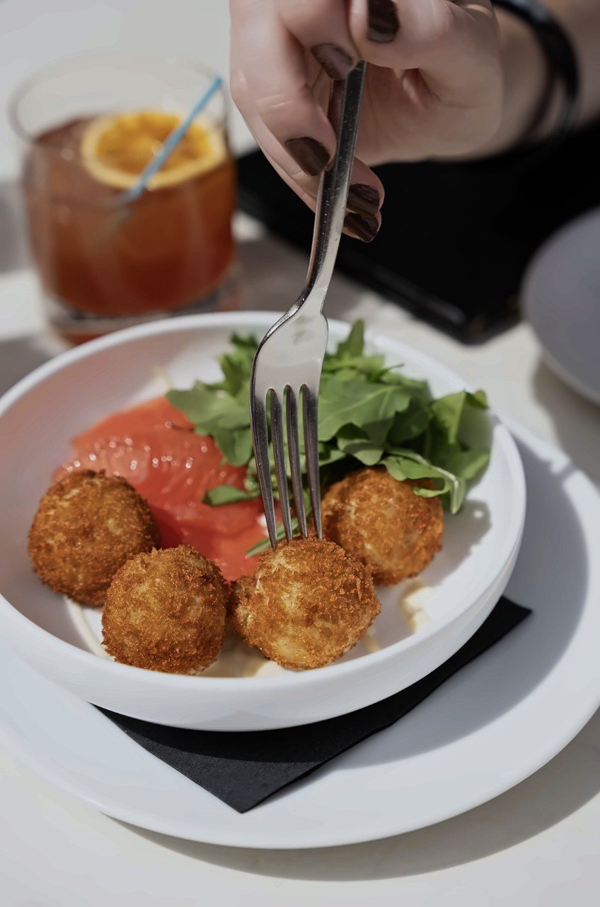 Croquettes and a cocktail at a bar table