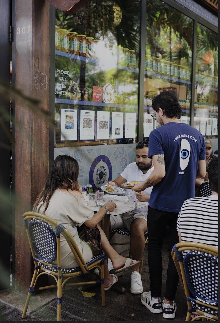Server bringing plates to guests on the El Turco patio
