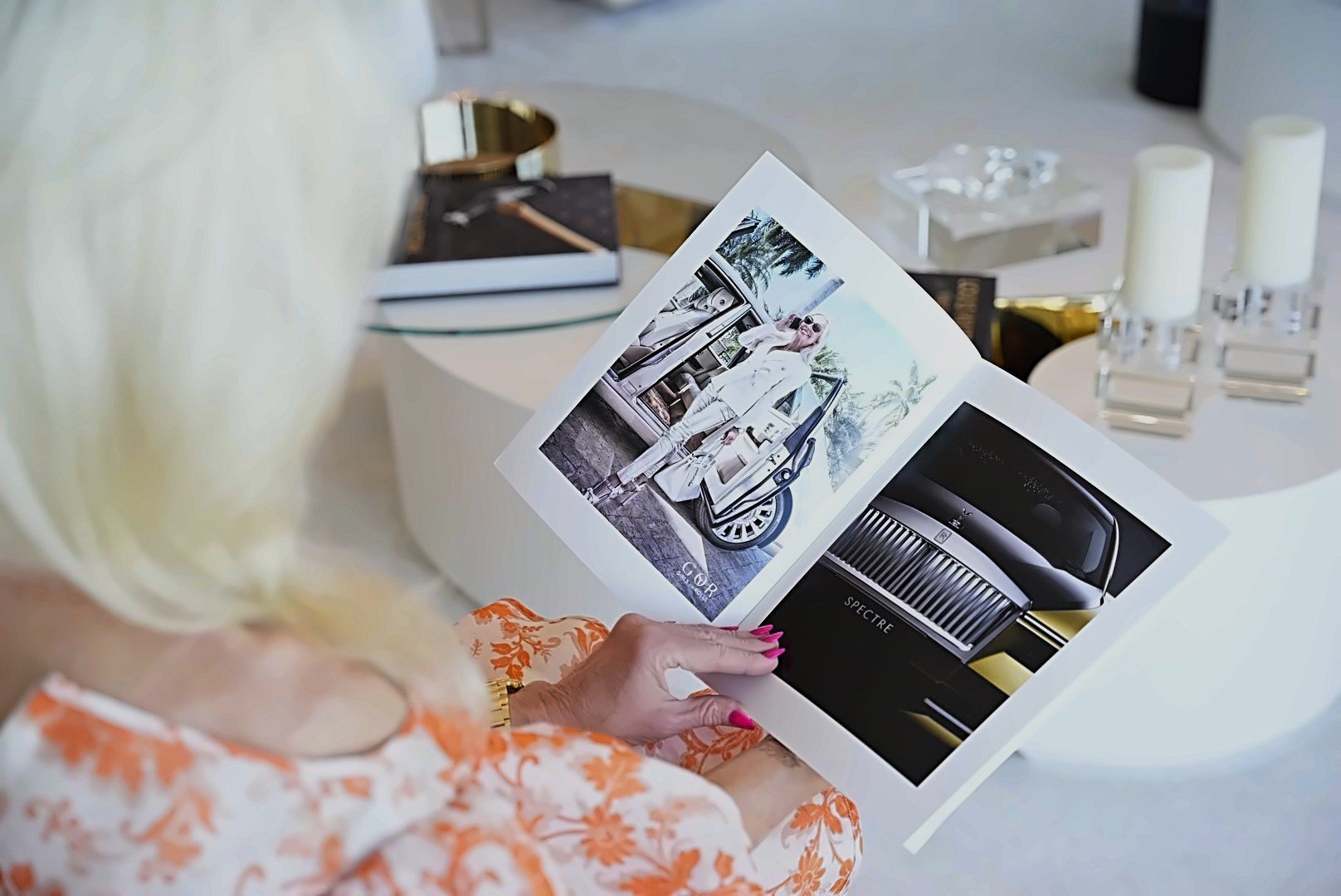 Reader holding Global Billionaire magazine open to a luxury print ad